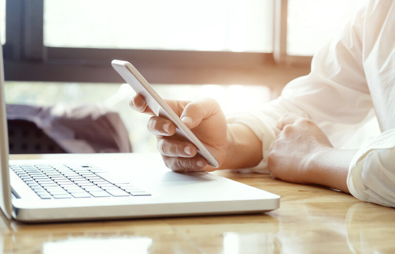 Businessman using laptop and mobile phone. Businessman using laptop and mobile phone for online communication.